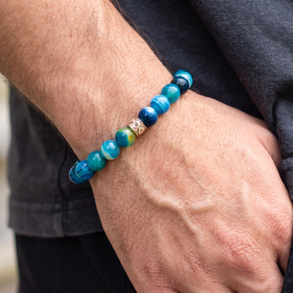 Agate bead bracelet on a man’s wrist in blue and teal with silver diamond centerpiece