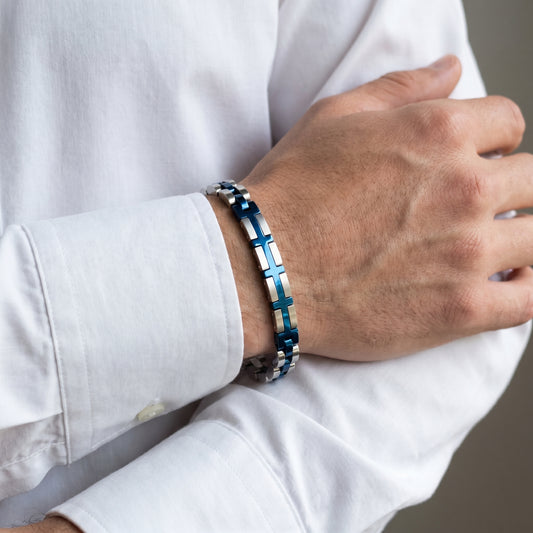 Men's wrist wearing silver-and-blue cross-link bracelet under white shirt cuff