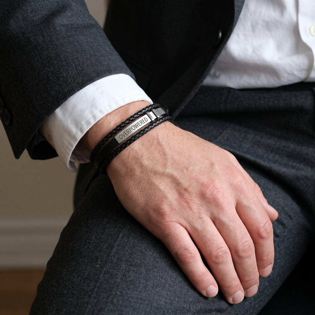 Men's black leather bracelet with adjustable strap and engraved 'OVERPOWERED' logo