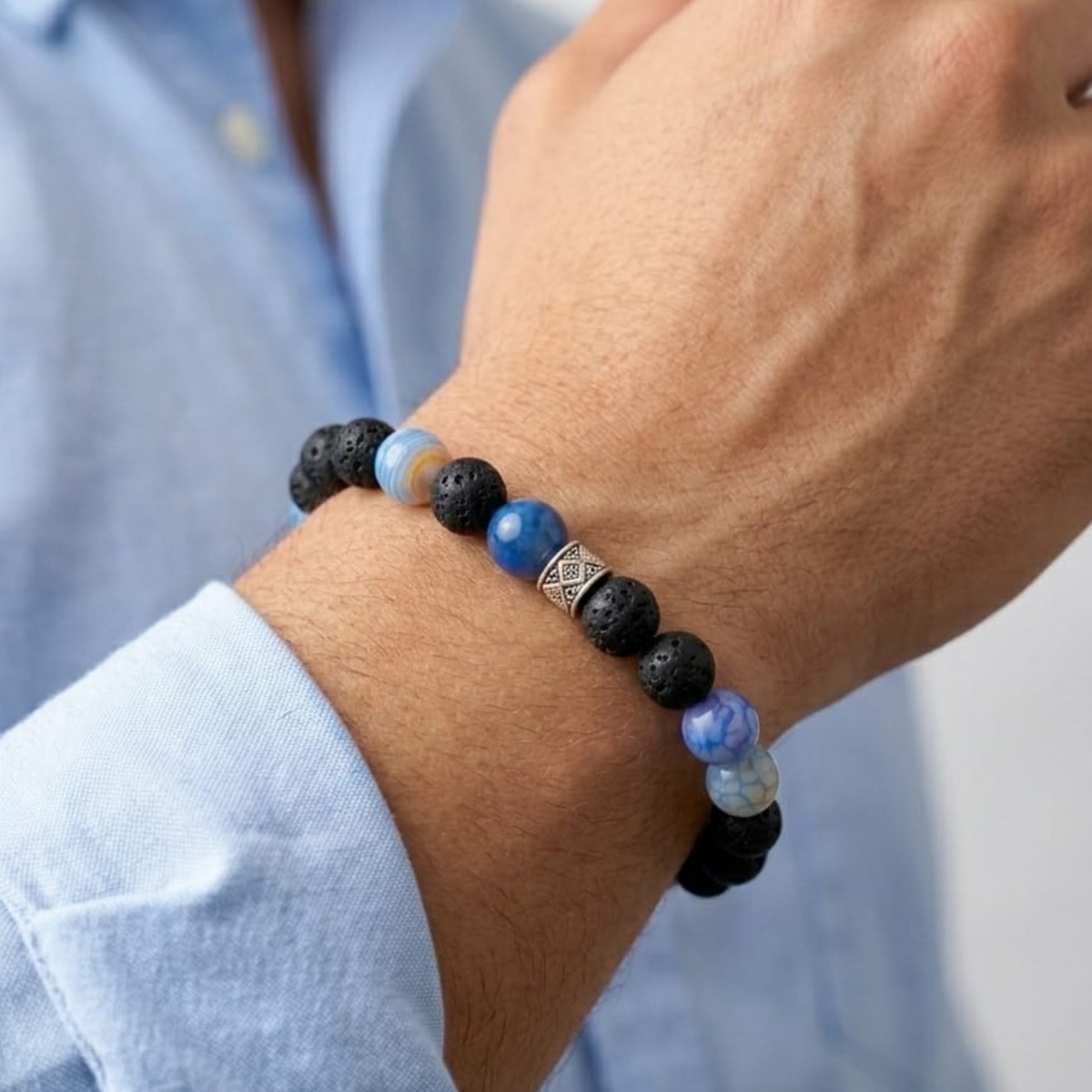 Men's beaded bracelet with black lava and blue stone beads on wrist