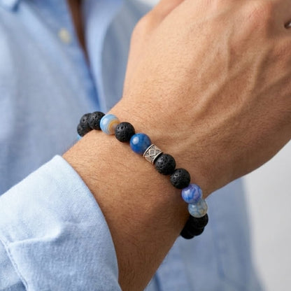 Men's beaded bracelet with black lava and blue stone beads on wrist