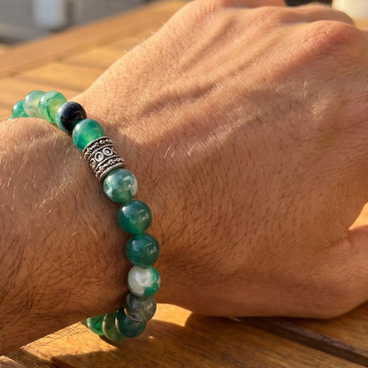 Green agate bead bracelet on wrist with ornate silver-tone centerpiece