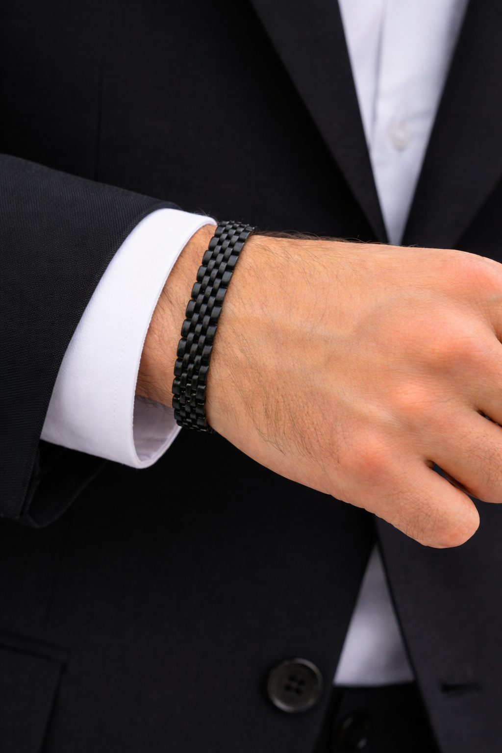 Sleek Black Stainless Steel B-16 Bracelet worn on a man's wrist, complementing a formal suit.