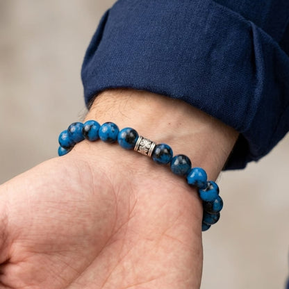 Men's stone bead bracelet worn on wrist with dark blue shirt sleeve