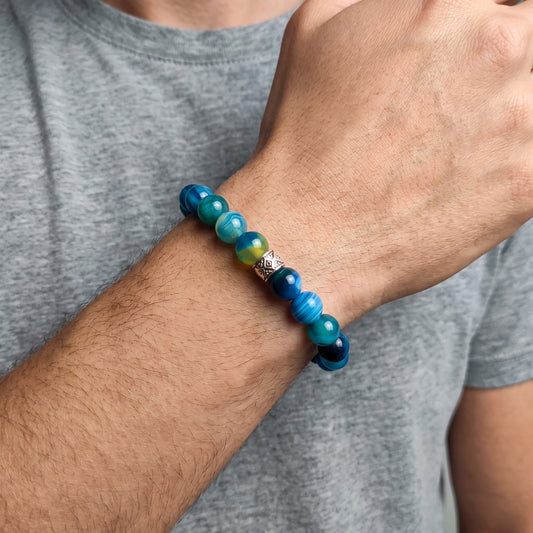 Agate bead bracelet on a man’s wrist: blue and teal round beads with silver diamond clasp