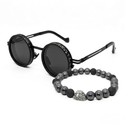 Men's sunglasses with round black frames and dark lenses, paired with a beaded bracelet featuring silver and black stones.
