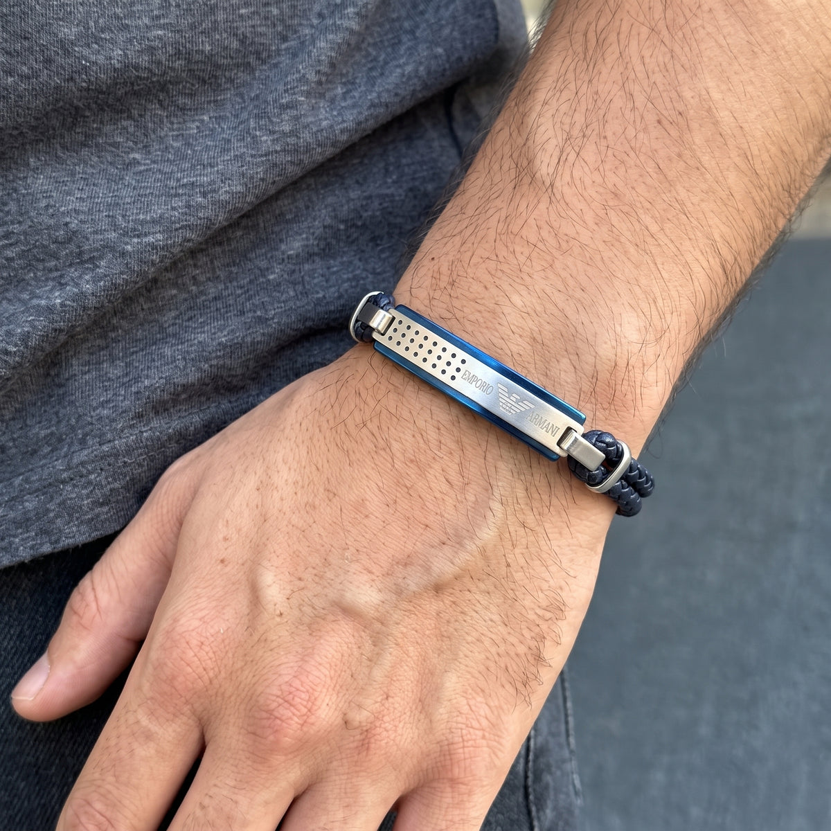 Men's braided leather bracelet with blue metal bar and silver accents on wrist
