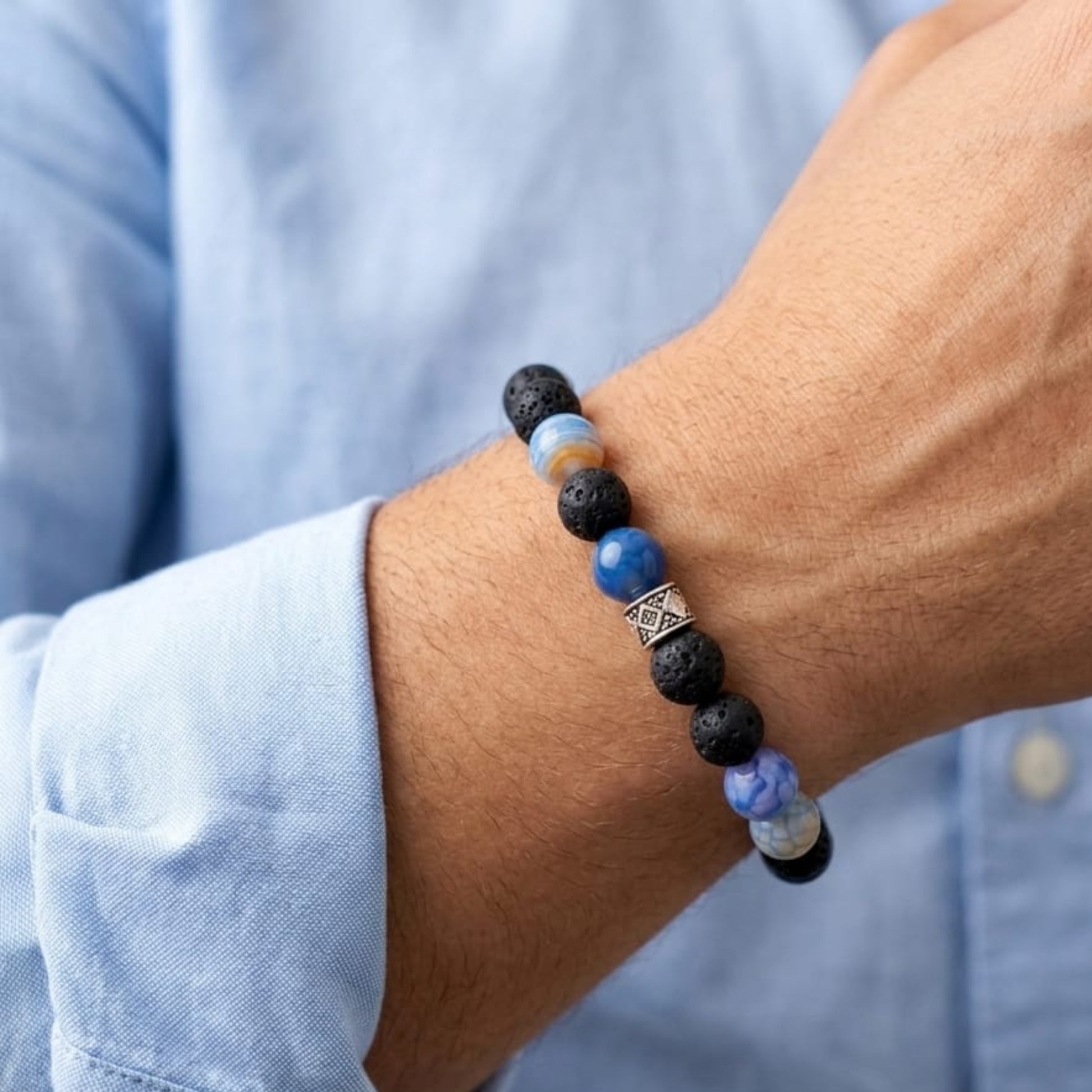 Men's Summit Authority Bundle G-11 SG-002 bracelet featuring blue and black beads, worn on a wrist with a light blue shirt.