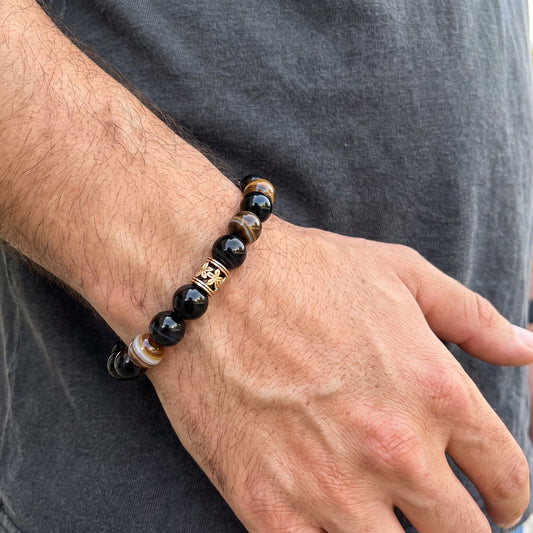 Men's agate bracelet on wrist with gold-tone centerpiece and brown accent beads