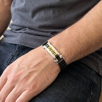 Stainless steel Greek key bracelet with black links and gold trim, silver clasp on wrist