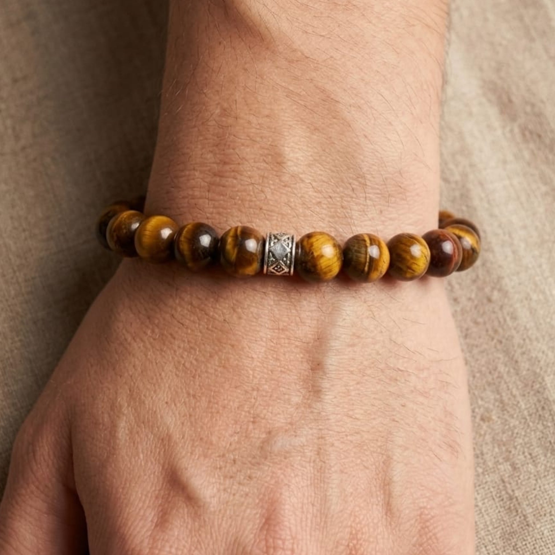 Men's Vigilant Vision Bundle G-8 SG-001 featuring a tiger's eye bracelet with silver accents on a hand.