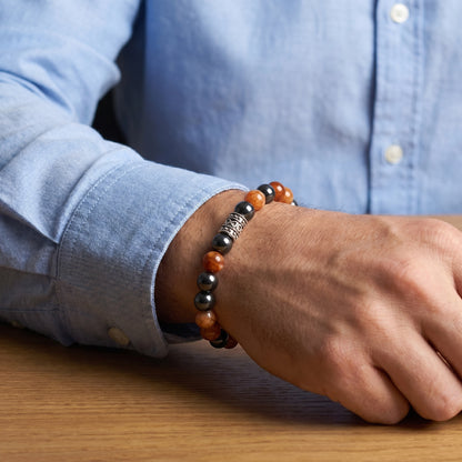 Natural Agate & Hematite G-20 Stone Bracelet on a man's wrist, featuring orange and black beads with a decorative silver acce
