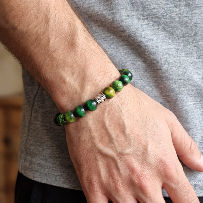 Green tiger's eye stone bead bracelet worn on wrist with silver-toned clasp centerpiece.