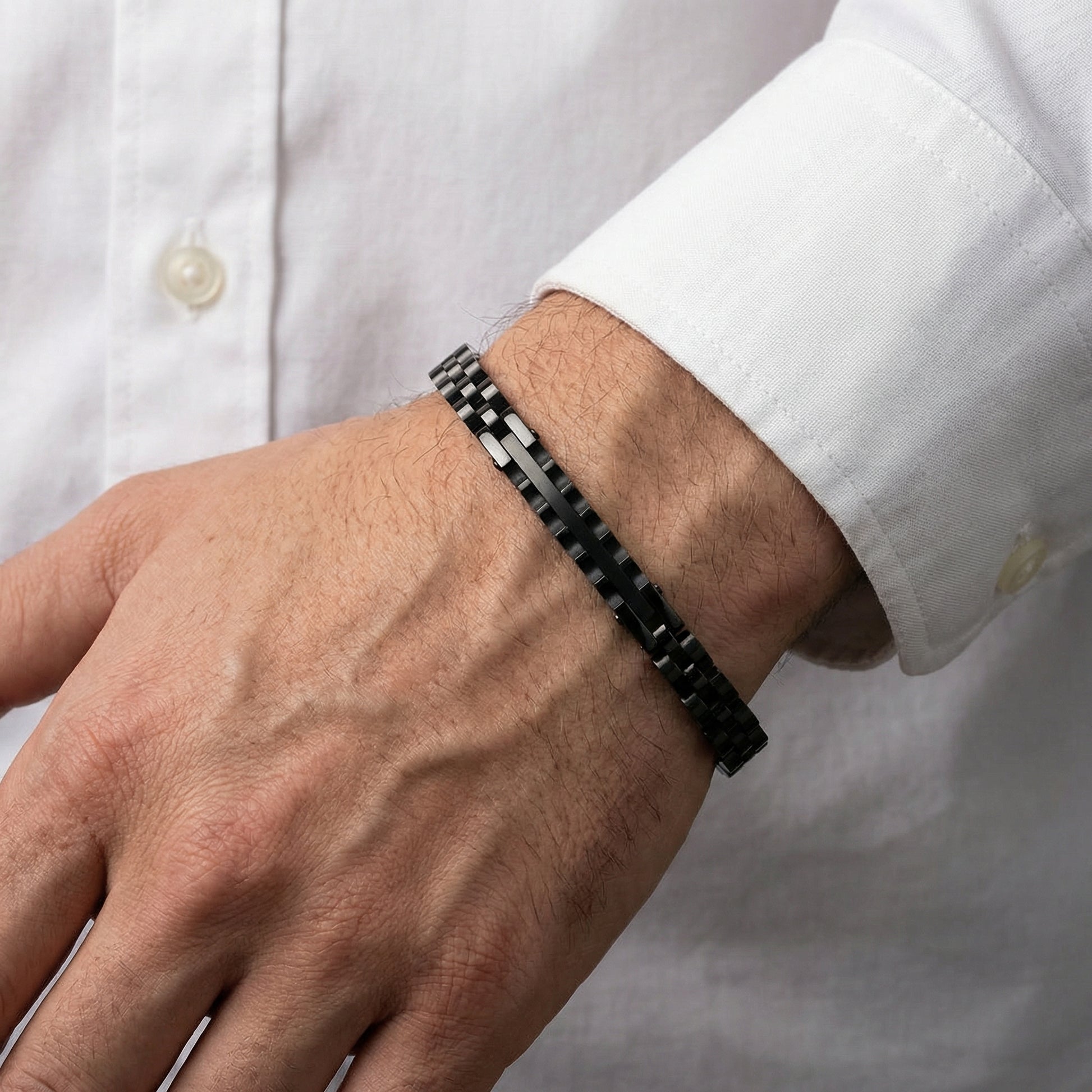 Men's black stainless steel link bracelet on wrist with rectangular segment links