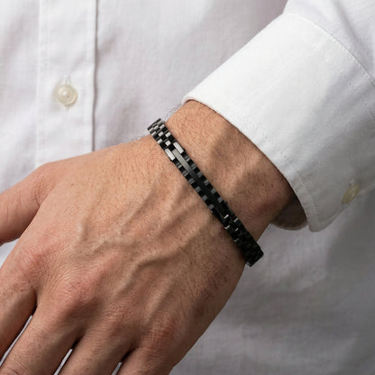 Men's black stainless steel link bracelet on wrist with rectangular segment links