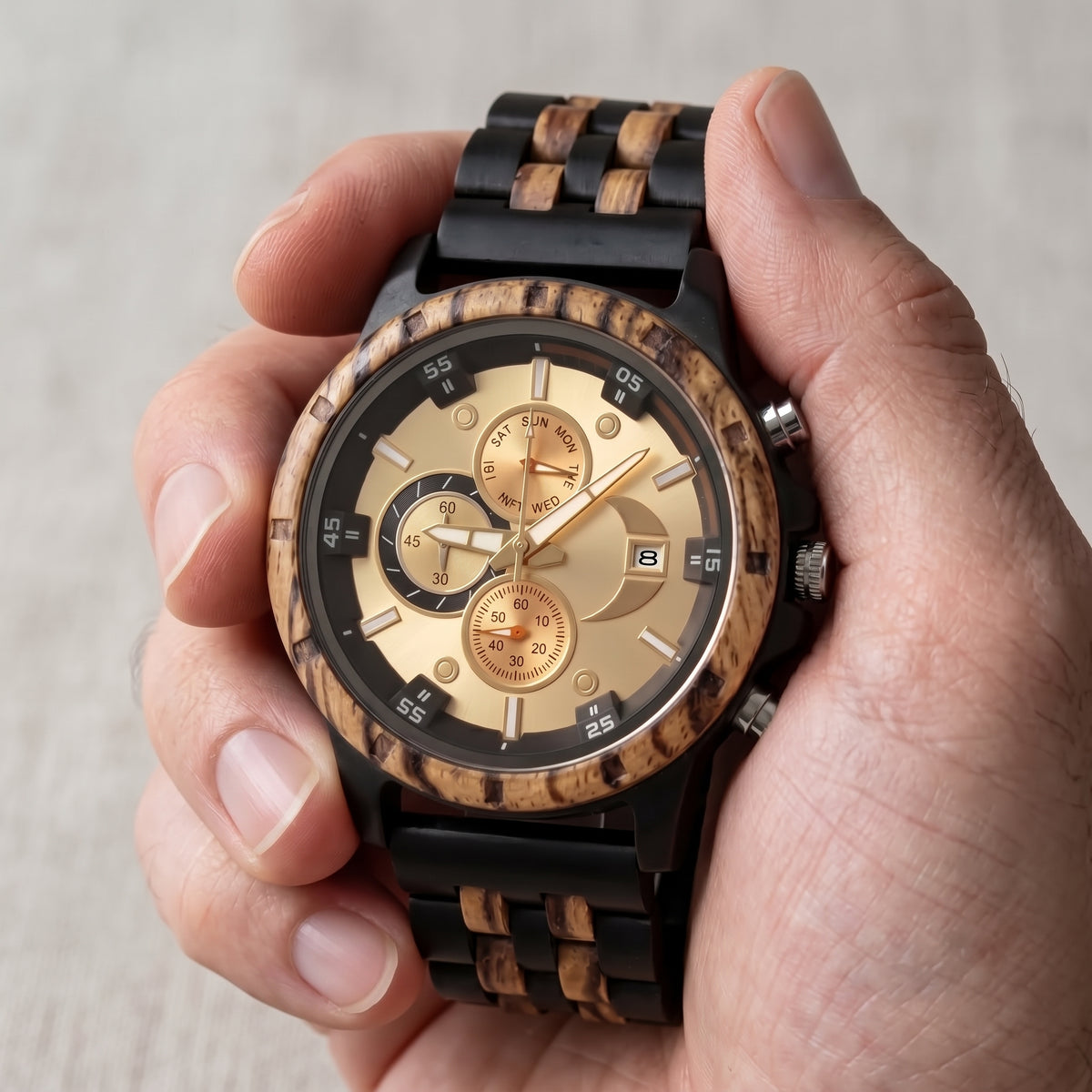 Men's wooden wristwatch held in hand, cream dial, subdials, zebrawood/ebony band, Overpowered Accessories