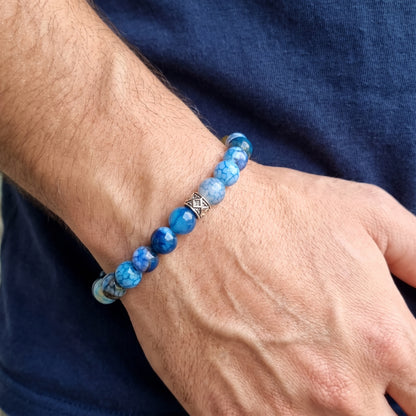 Blue agate bead bracelet on wrist with diamond-pattern metal centerpiece