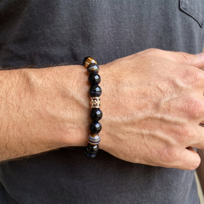 Men's agate bracelet worn on wrist, dark round beads with gold-tone caps