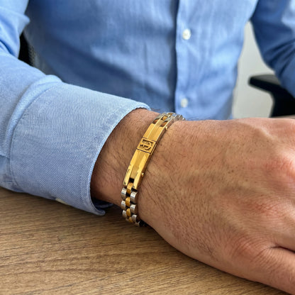 Anchor bracelet on forearm in two-tone gold and silver with gold center bar and silver links