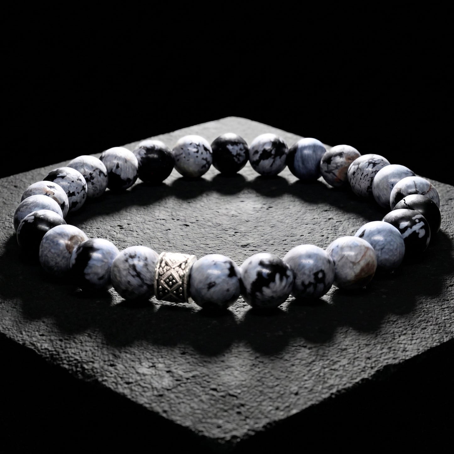 Men's gray obsidian bead bracelet with carved metal spacer and elastic fit