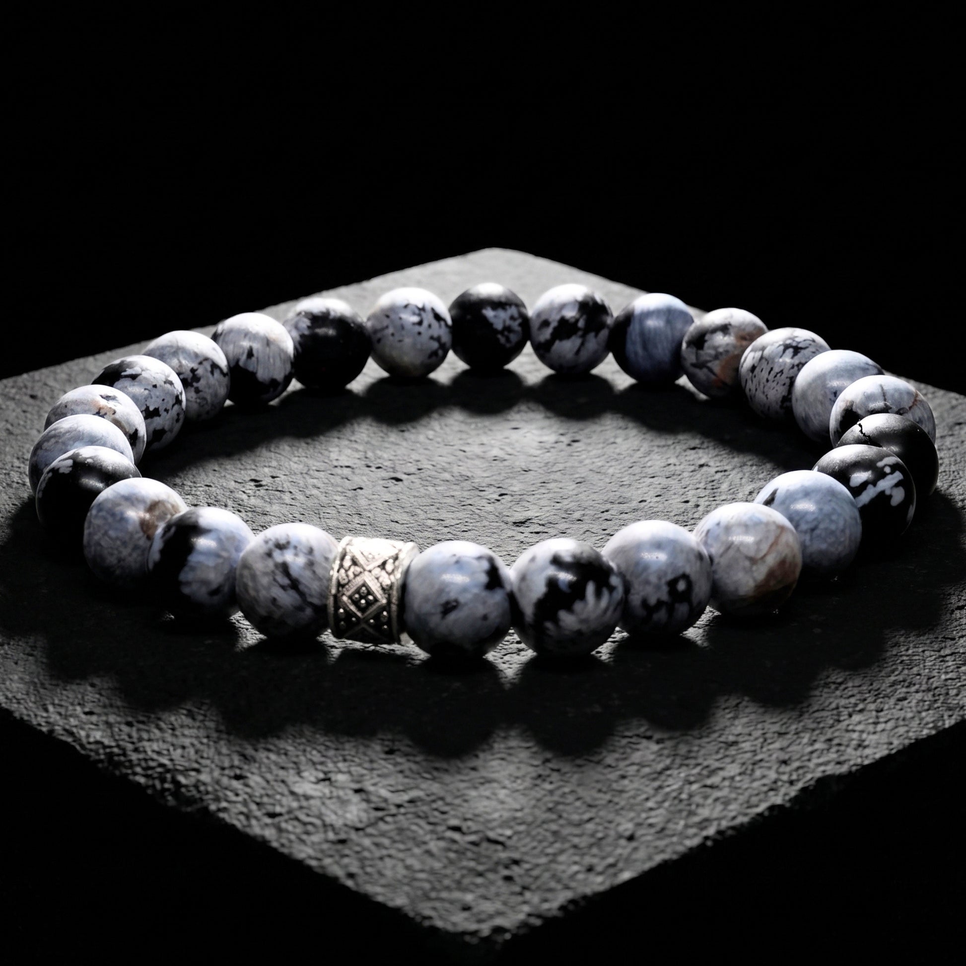 Men's gray obsidian bead bracelet with carved metal spacer and elastic fit