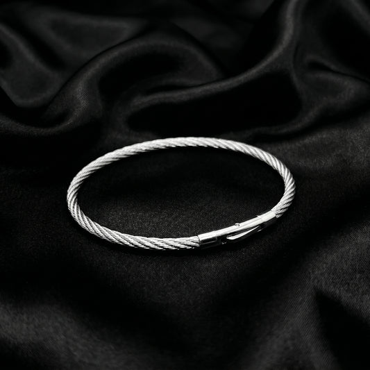 Silver stainless steel bracelet with a magnetic clasp, featuring a twisted cable design, displayed on a black satin backgroun